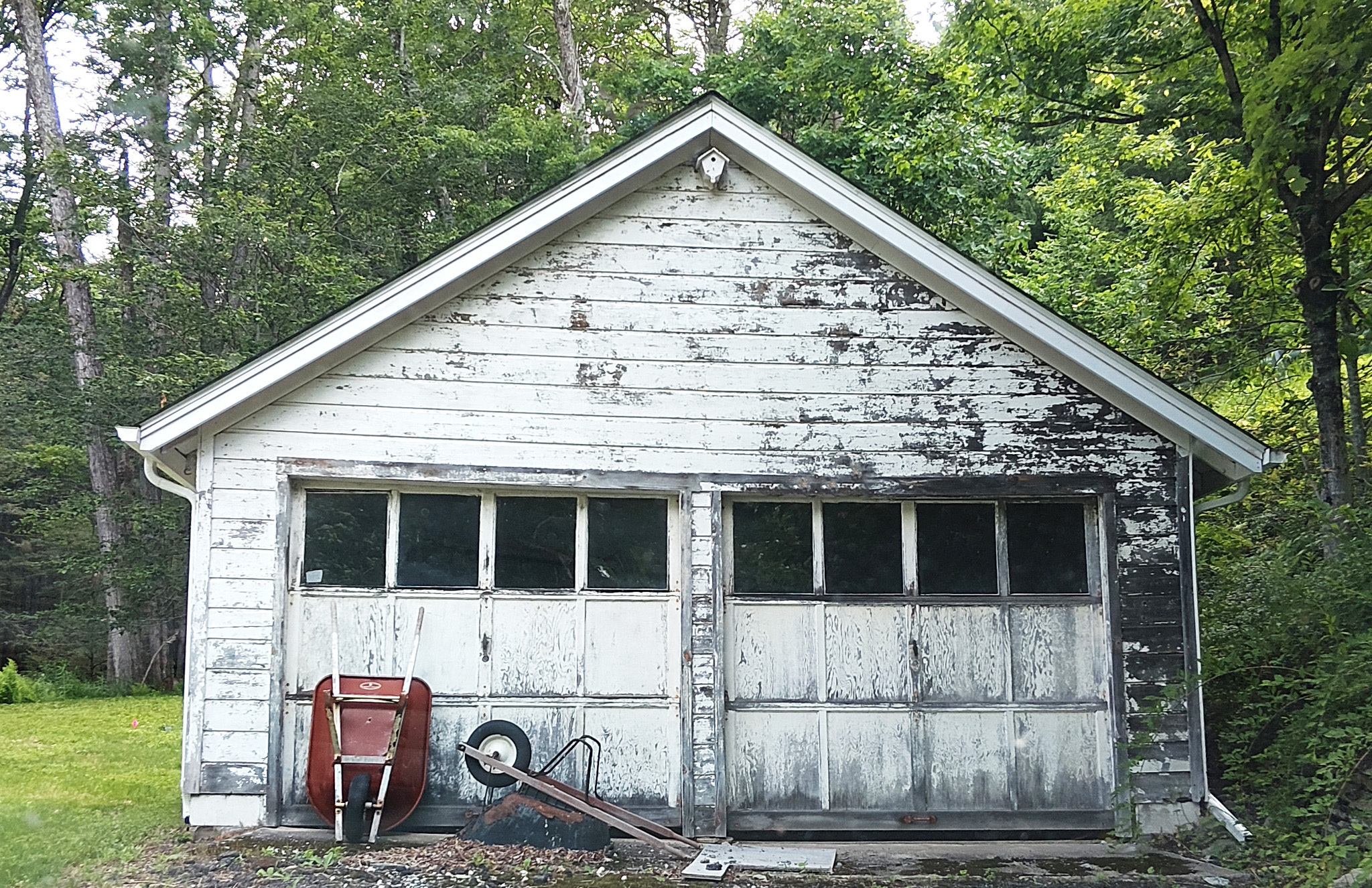 Old wood garage in Grahamsville, New York, with weathered boards and failing exterior paint before restoration