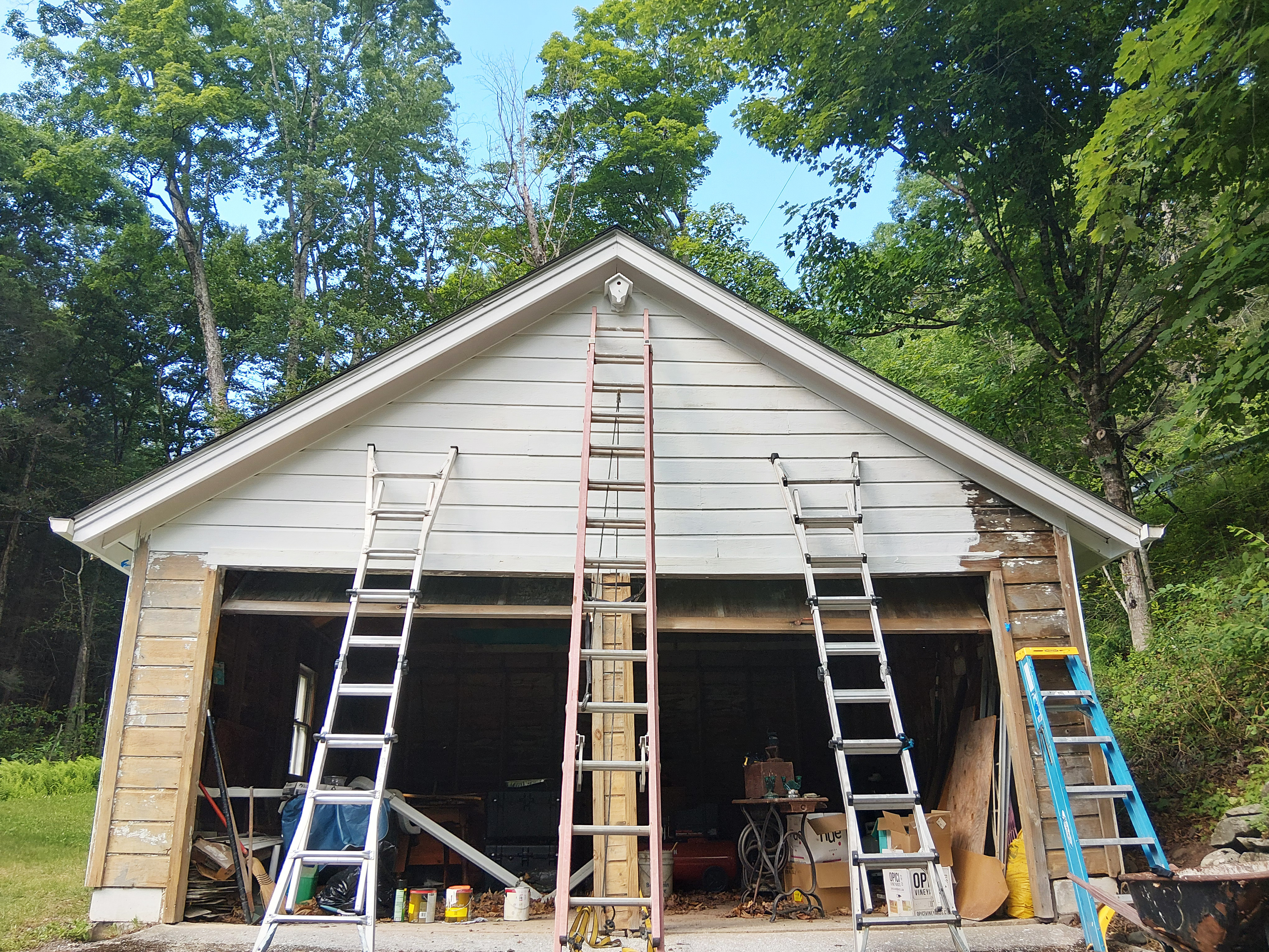 Hudson Valley Home Painters preparing and painting hard-to-reach areas on a wood garage exterior