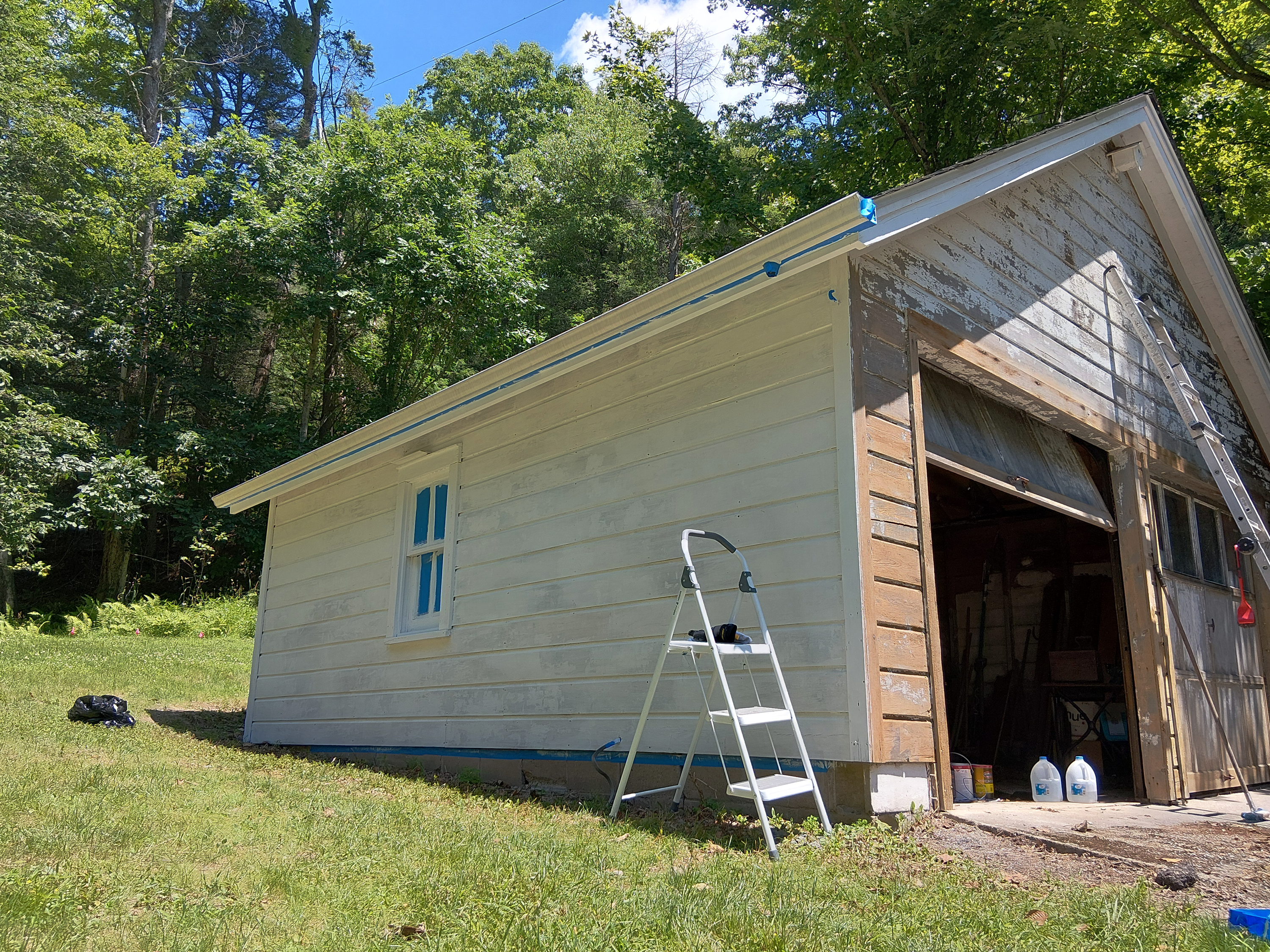 Masked and primed wood garage siding before exterior painting